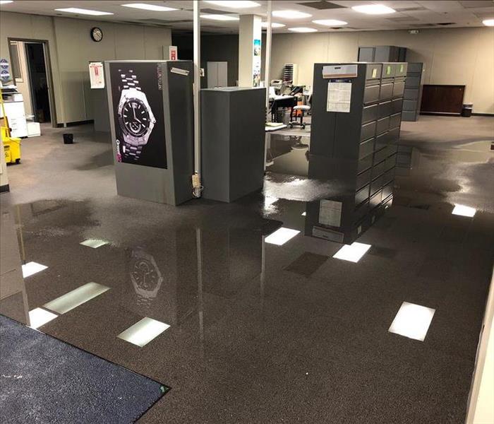 Open office space with big pool of water on the floor after a water loss.