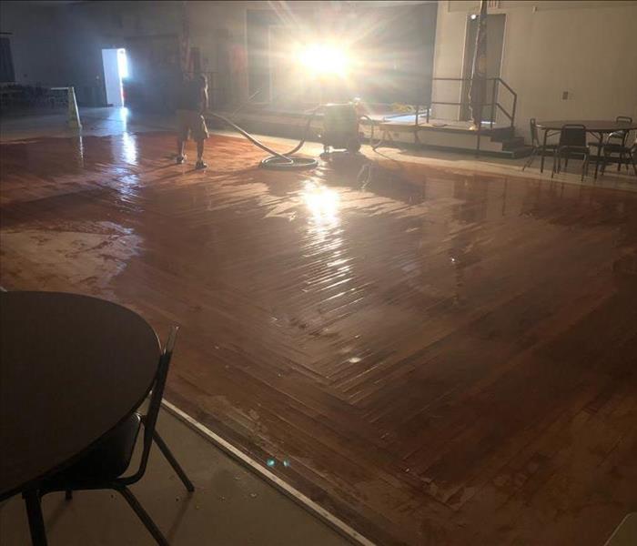 Water damaged wood flooring in a large room.