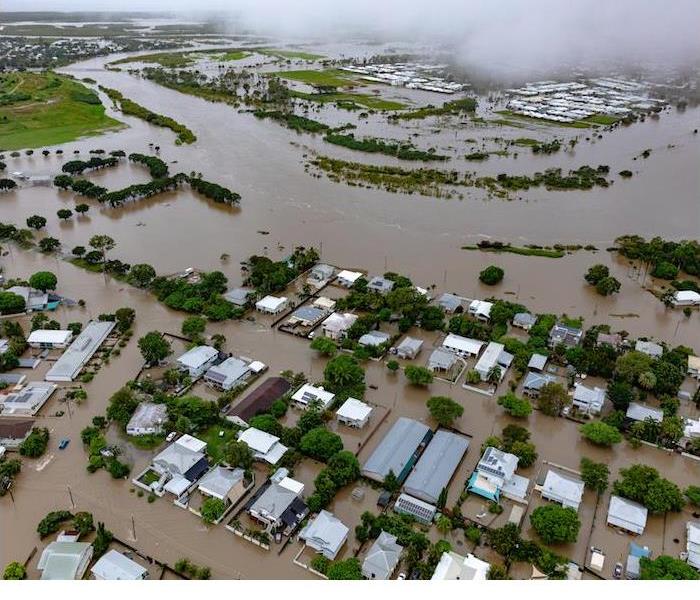 Overhead view of homes surrounded by rising floodwaters.